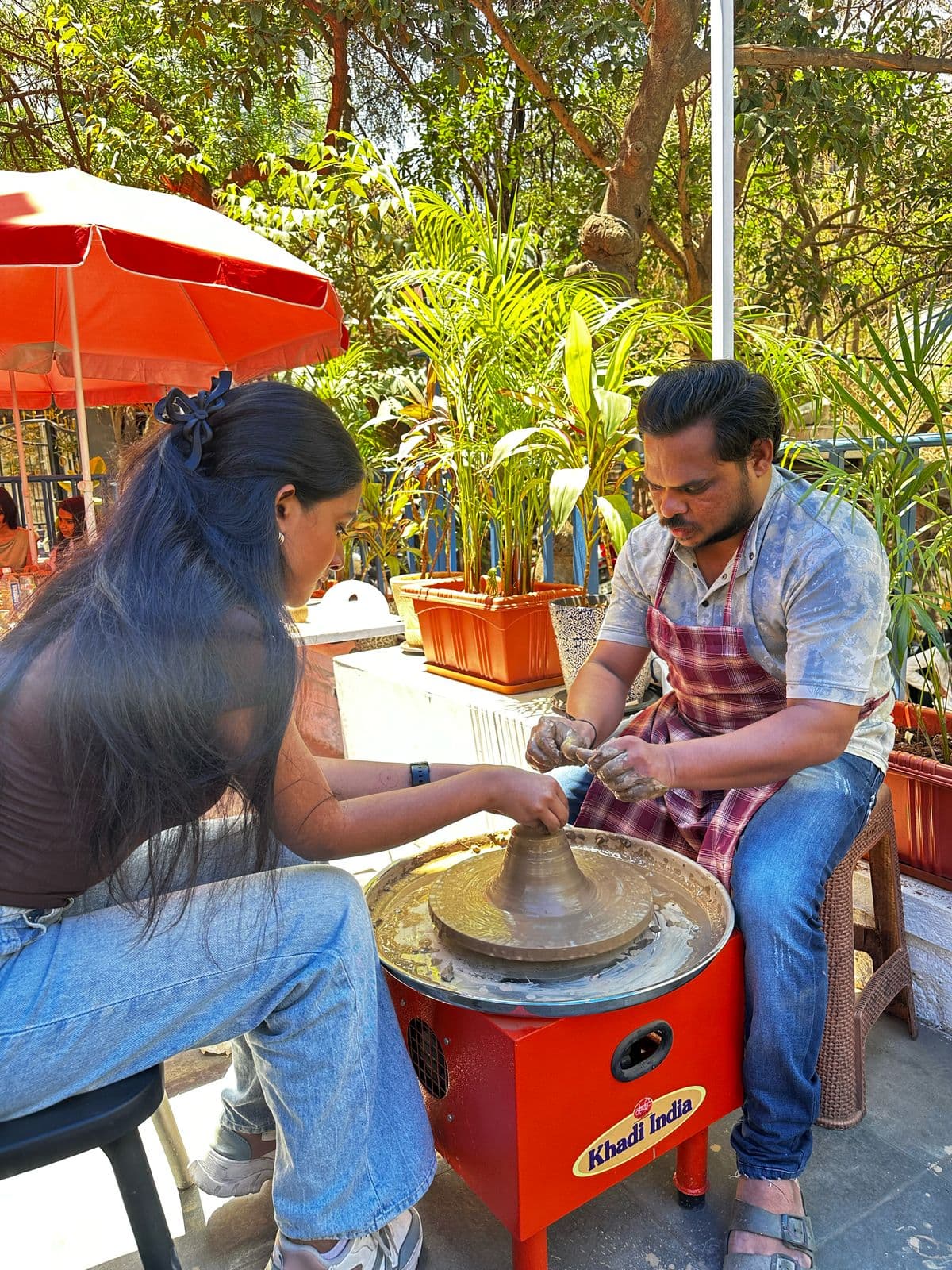 A child and parent shaping clay together